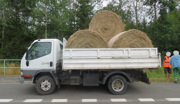 Řidič nedostatečně upevnil náklad, balík slámy spadl na projíždějící auto.
