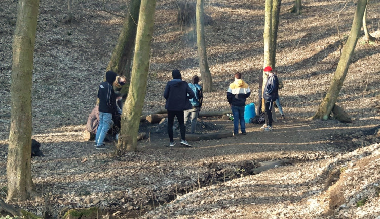 Skupinka mladých lidí si v lese rozdělala oheň a chtěli opékat buřty