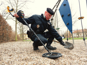 Strážník s detektorem kovu kontroluje hřiště v Habrmanově parku