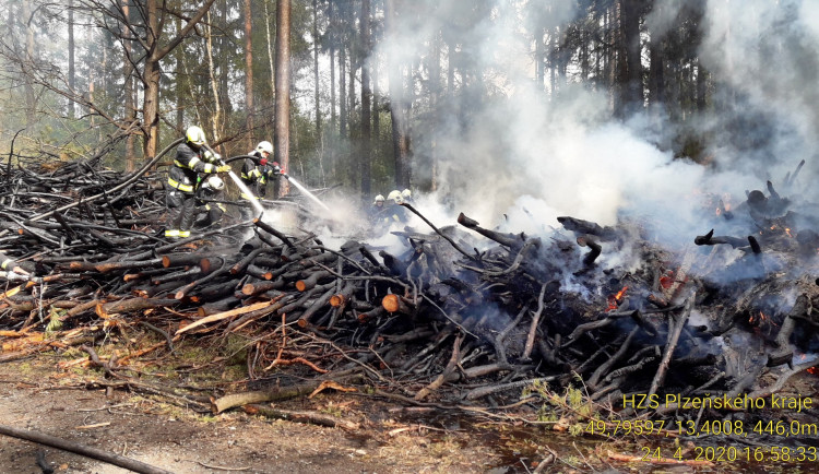 Hasiči likvidují požár hromad větví