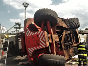 Hasiči vyprošťovali zraněného řidiče z kabiny převráceného obřího nakladače