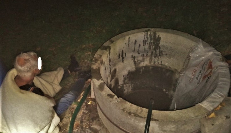 Zachráněný muž vedle studny, která se mohla stát jeho hrobem