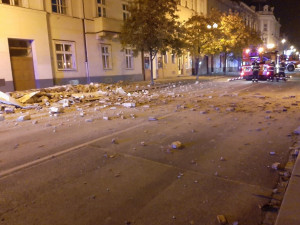 Chodník i ulici zasypaly sutiny z římsy, která se nad ránem utrhla z domu v Husově ulici