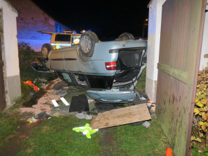 Auto zbořilo hradbu a přistálo na střeše ve vjezdu dalšího domu, řidič od nehody ujel jiným vozem