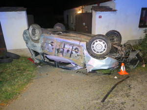 Auto zbořilo hradbu a přistálo na střeše ve vjezdu dalšího domu, řidič od nehody ujel jiným vozem