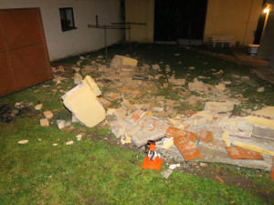 Auto zbořilo hradbu a přistálo na střeše ve vjezdu dalšího domu, řidič od nehody ujel jiným vozem