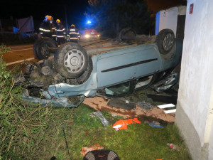 Auto zbořilo hradbu a přistálo na střeše ve vjezdu dalšího domu, řidič od nehody ujel jiným vozem