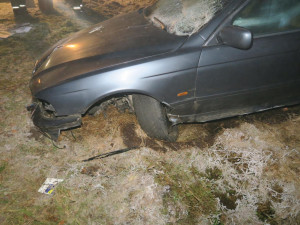 Řidič BMW po smyku na namrzlé silnici smetl dopravní značky i reklamní tabuli