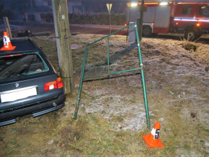 Řidič BMW po smyku na namrzlé silnici smetl dopravní značky i reklamní tabuli