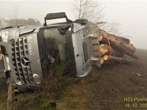 Kamion se převrátil a vysypal náklad dřeva, řidička osobáku zase vyvrátila strom a skončila na střeše v jabloňovém sadu