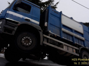 Vůz popelářů zůstal viset mimo vozovku, nejspíš sklouzl po zasněžené krajnici