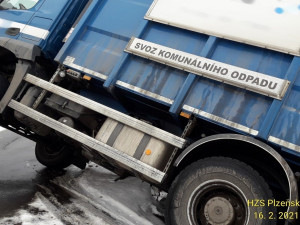 Vůz popelářů zůstal viset mimo vozovku, nejspíš sklouzl po zasněžené krajnici