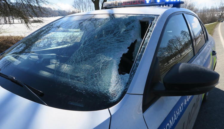 Kus ledu proletěl čelním sklem policejního vozu, jen těsně minul řidičku a spolujezdce