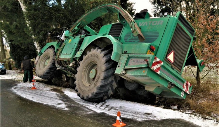 Po smyku na kluzké vozovce ukončil těžký stavební stroj svoji jízdu nárazem do stromů