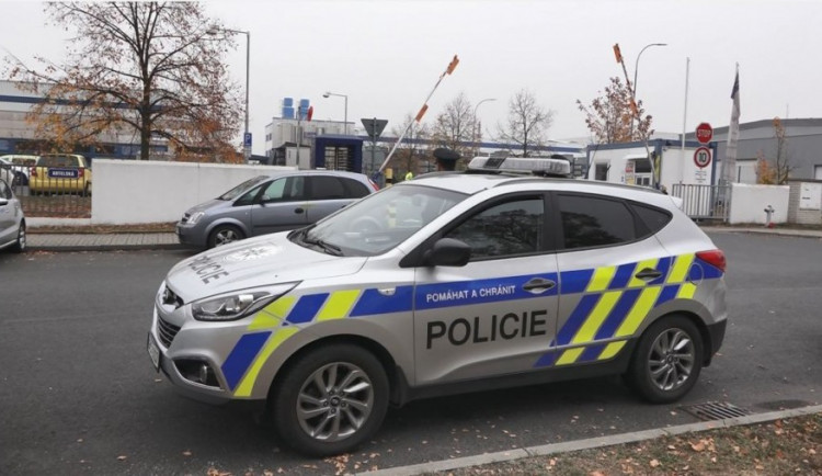 Policisté na místě tragické střelby. V pozadí je vůz, ve které seděla oběť
