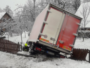 Zasněžené a namrzlé silnice potrápily řidiče, jeden náklaďák skončil v plotě, druhý naboural do domu