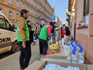 Dobrovolníci z centra Totem nabízí lidem teplý čaj, ovoce nebo sladkosti pro děti.