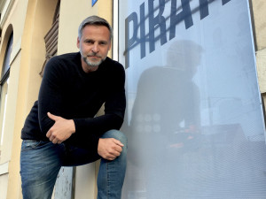 Pirátský zastupitel Pavel Bosák u poničené výlohy pirátského centra