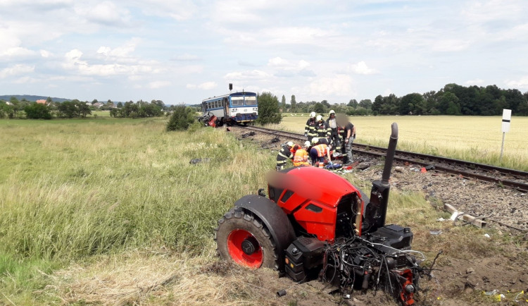 Vlak na přejezdu smetl traktor, řidič utrpěl těžké zranění. Záchranáři ošetřili zraněné pasažéry