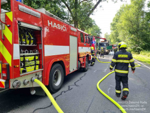 Kamion s nákladem dřeva náhle vzplál, statečný řidič dokázal hydraulickou rukou vyložit většinu hořících klád