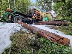 Kamion s nákladem dřeva náhle vzplál, statečný řidič dokázal hydraulickou rukou vyložit většinu hořících klád