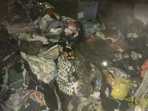 Hasiči likvidovali požár uvnitř bytu zaplněného harampádím, které komplikovalo zásah