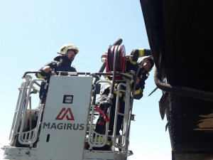 Obyvatelé bytového domu opustili kvůli požáru své domovy, jeden hasič při zásahu zkolaboval