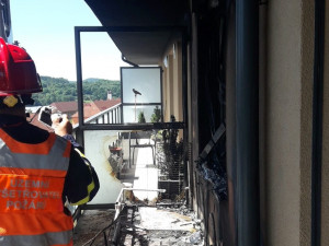 Obyvatelé bytového domu opustili kvůli požáru své domovy, jeden hasič při zásahu zkolaboval