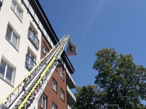 Obyvatelé bytového domu opustili kvůli požáru své domovy, jeden hasič při zásahu zkolaboval