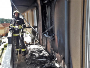 Obyvatelé bytového domu opustili kvůli požáru své domovy, jeden hasič při zásahu zkolaboval