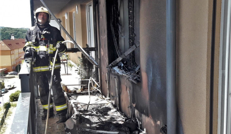 Obyvatelé bytového domu opustili kvůli požáru své domovy, jeden hasič při zásahu zkolaboval