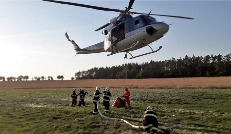 Hasiči bojují s rozsáhlými požáry polí i lesů, vzlétnout musel i vrtulník s Bambi vakem