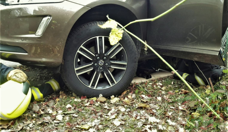 Hasiči vyprošťují vážně zraněného muže, kterého přejelo jeho vlastní auto