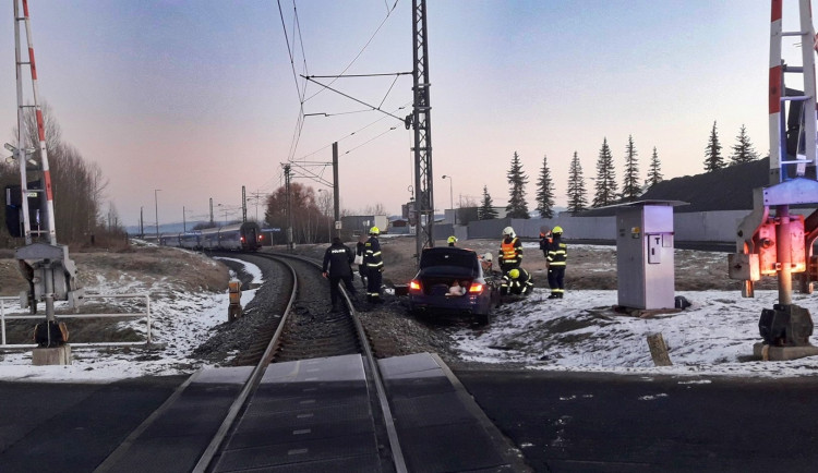 Osobní BMW vjelo na železniční přejezd a střetlo se s vlakem, spolujezdkyně utrpěla těžké zranění