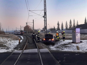Osobní BMW vjelo na železniční přejezd a střetlo se s vlakem, spolujezdkyně utrpěla těžké zranění