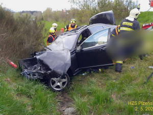 Při hrozivém čelním střetu luxusního mercedesu s nákladním vozidlem pro přepravu dřeva se těžce zranili dva lidé