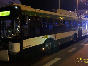 Trolejbus po střetu odmrštil osobní automobil přes chodník a zábradlí až na zeď s billboardem. Dva lidé se zranili