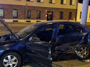 Trolejbus po střetu odmrštil osobní automobil přes chodník a zábradlí až na zeď s billboardem. Dva lidé se zranili
