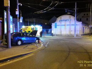 Trolejbus po střetu odmrštil osobní automobil přes chodník a zábradlí až na zeď s billboardem. Dva lidé se zranili