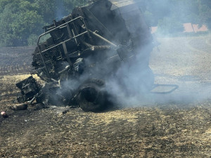 V příšerném vedru bojují hasiči s obrovským požárem pole a lesa na ploše 25 hektarů. Hořet začalo od balíkovače