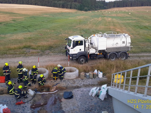 Z protrženého pláště převrácené cisterny unikají po ranní nehodě tisíce litrů benzínu do kanálu