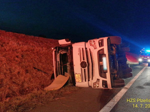Z protrženého pláště převrácené cisterny unikají po ranní nehodě tisíce litrů benzínu do kanálu