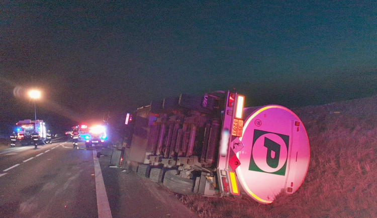 Z protrženého pláště převrácené cisterny unikají po ranní nehodě tisíce litrů benzínu do kanálu