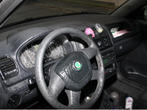 Následky útoku kyselinou v interiéru automobilu