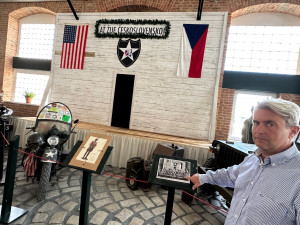 Roman Jurečko ukazuje fotografii s originální tribunou. Její kopie je nyní součástí muzea