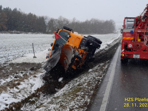 Převrácený sypač i celá řada dalších nehod. Tak vypadá úterý na zasněžených silnicích v Plzeňském kraji