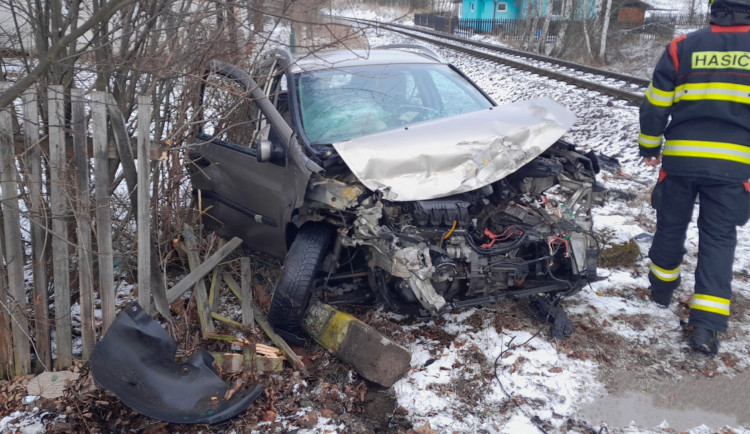Vlak smetl na železničním přejezdu osobní automobil. Náraz odmrštil zdemolovaný vůz až na plot zahrady