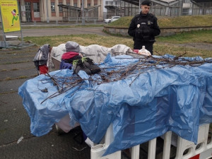 Dva bezdomovci si postavili ležení z bezpečnostních zábran na náměstí, sušili tam prádlo a rozdělávali oheň