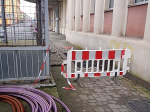 Dva bezdomovci si postavili ležení z bezpečnostních zábran na náměstí, sušili tam prádlo a rozdělávali oheň