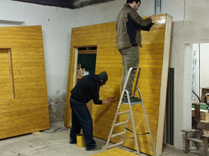 Bezdomovci pomáhají se stavbou mobilního domku, budou v něm pak přespávat